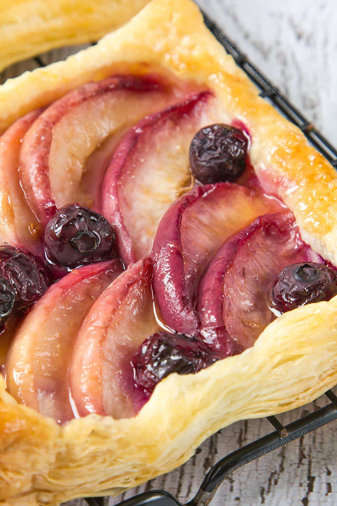My simple Peach and Blueberry Mini Tarts are so easy to make, yet bursting at the seams with sweet fruit. Shop bought puff pastry is layered with sliced peaches and fresh blueberries before being baked until golden. The perfect Summer dessert!