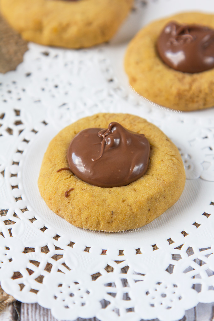 These Pumpkin Nutella Thumbprint Cookies are little bites of heaven. Spiced cookies, baked until slightly crisp, with gooey, rich Nutella spooned into the middle make these cookies simply irresistible! 