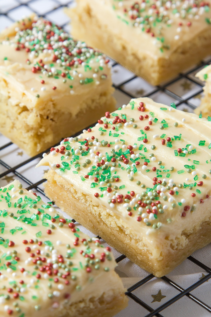 Thick and chewy Sugar cookie dough baked into bars and frosted with velvety smooth buttercream and festive sprinkles!