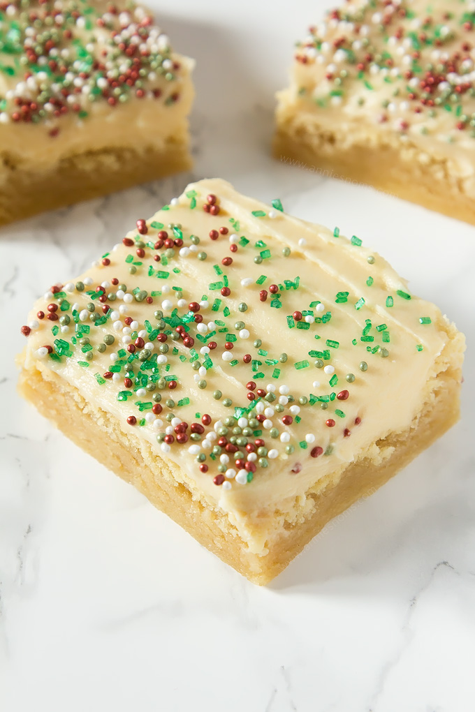 Thick and chewy Sugar cookie dough baked into bars and frosted with velvety smooth buttercream and festive sprinkles!