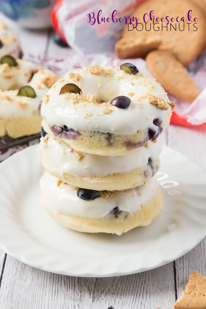 These Baked Blueberry Cheesecake Doughnuts are filled with juicy blueberries and topped with the most amazing cream cheese frosting and biscuit crumbs.