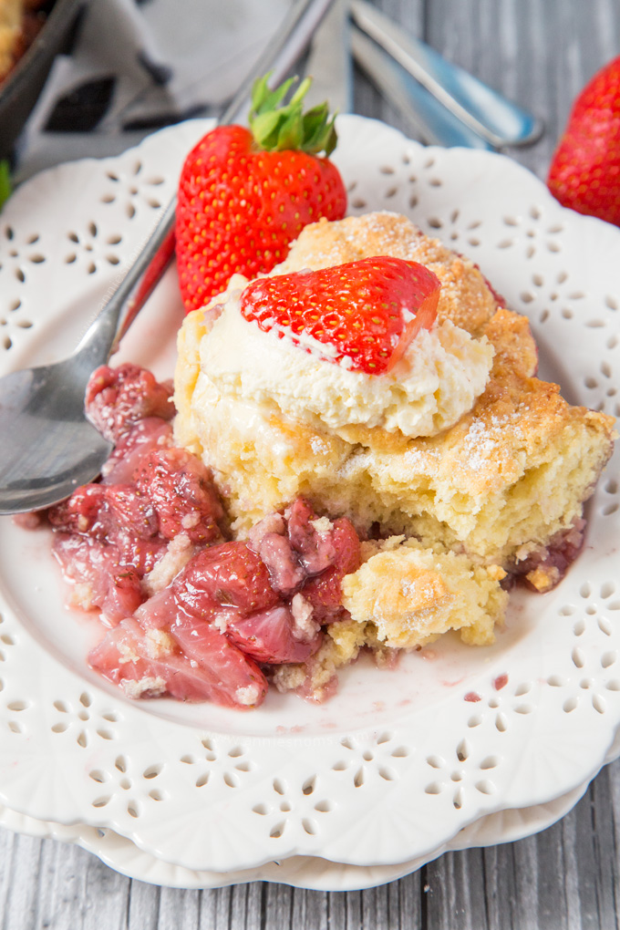 This Strawberry Shortcake Cobbler is filled with juicy strawberries, topped with a light as air shortcake and whipped cream; the perfect Summer dessert for sharing!