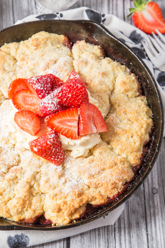 This Strawberry Shortcake Cobbler is filled with juicy strawberries, topped with a light as air shortcake and whipped cream; the perfect Summer dessert for sharing!