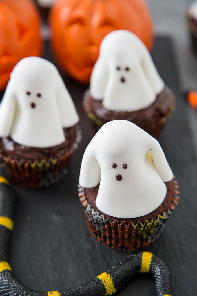 A chocolate frosted cupcake with a fondant ghost atop it; these Ghost Cupcakes are treats that adults and kids alike will love!