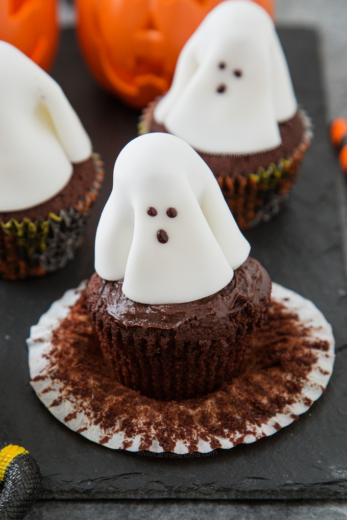 A chocolate frosted cupcake with a fondant ghost atop it; these Ghost Cupcakes are treats that adults and kids alike will love!