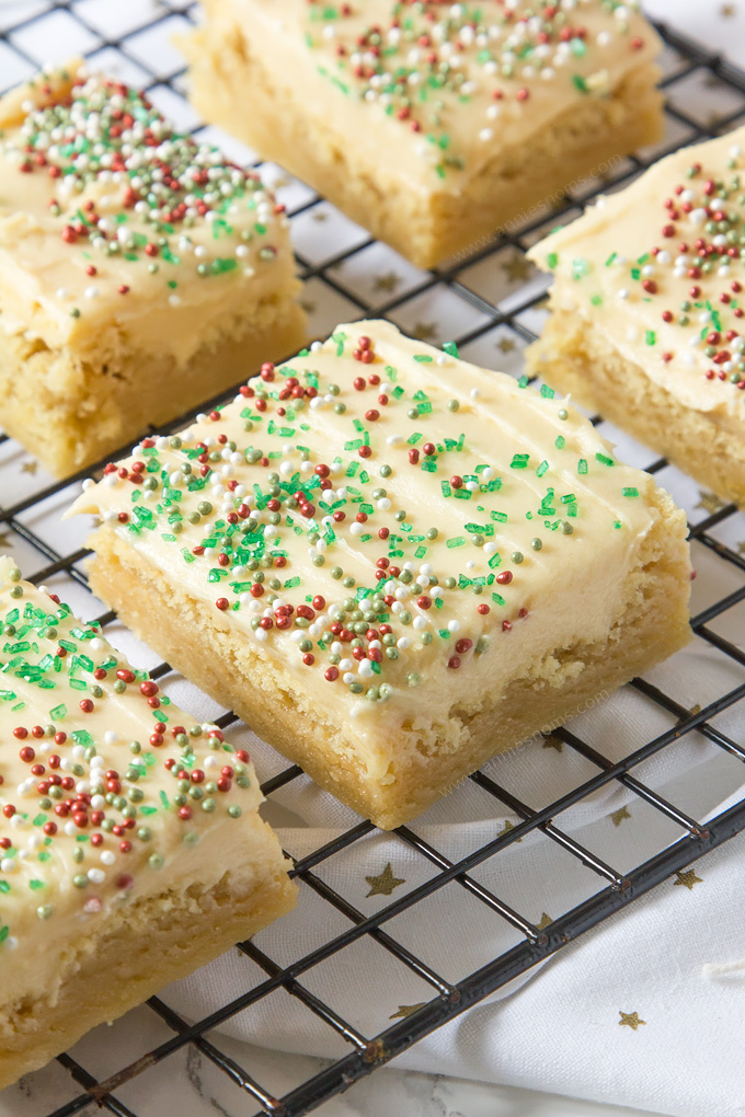 Thick and chewy Sugar cookie dough baked into bars and frosted with velvety smooth buttercream and festive sprinkles!