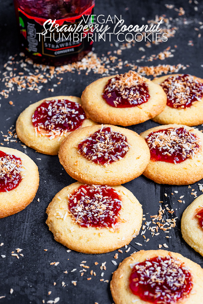 These Vegan Strawberry Coconut Thumbprint Cookies are so easy to make and taste amazing! Toasted coconut tops strawberry jam and a "buttery", cookie to make one bitesize delicious treat!